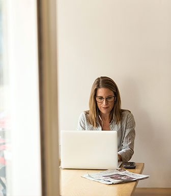 woman wearing glasses concentrating while working on laptop